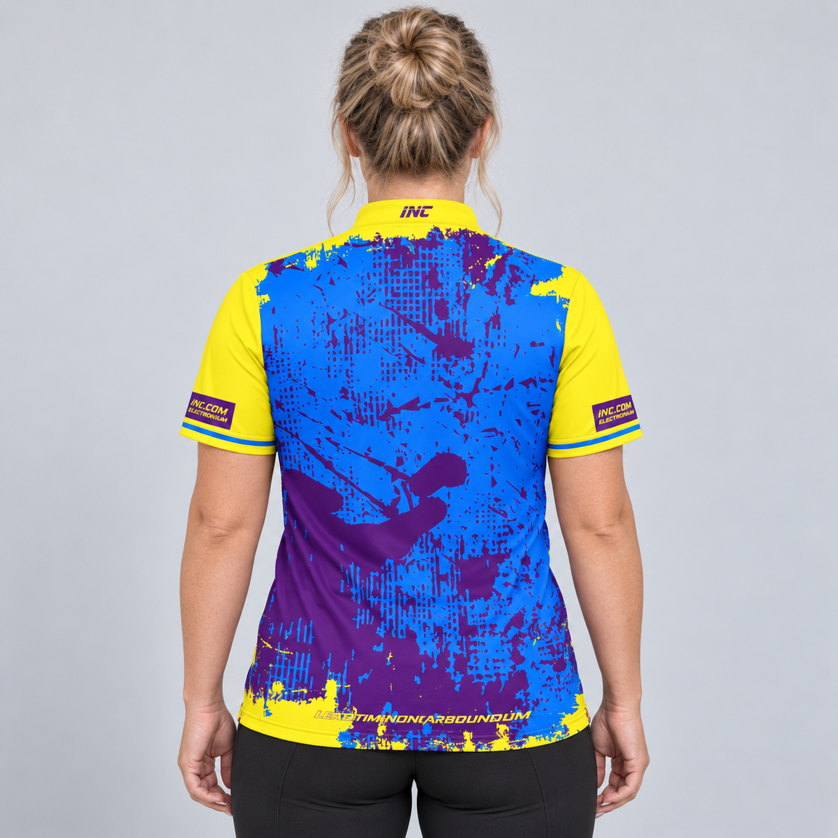 Back view of the Daemon Women's Yellow and Purple Darts Shirt, highlighting the breathable contoured back paneling and flexible shoulder construction.