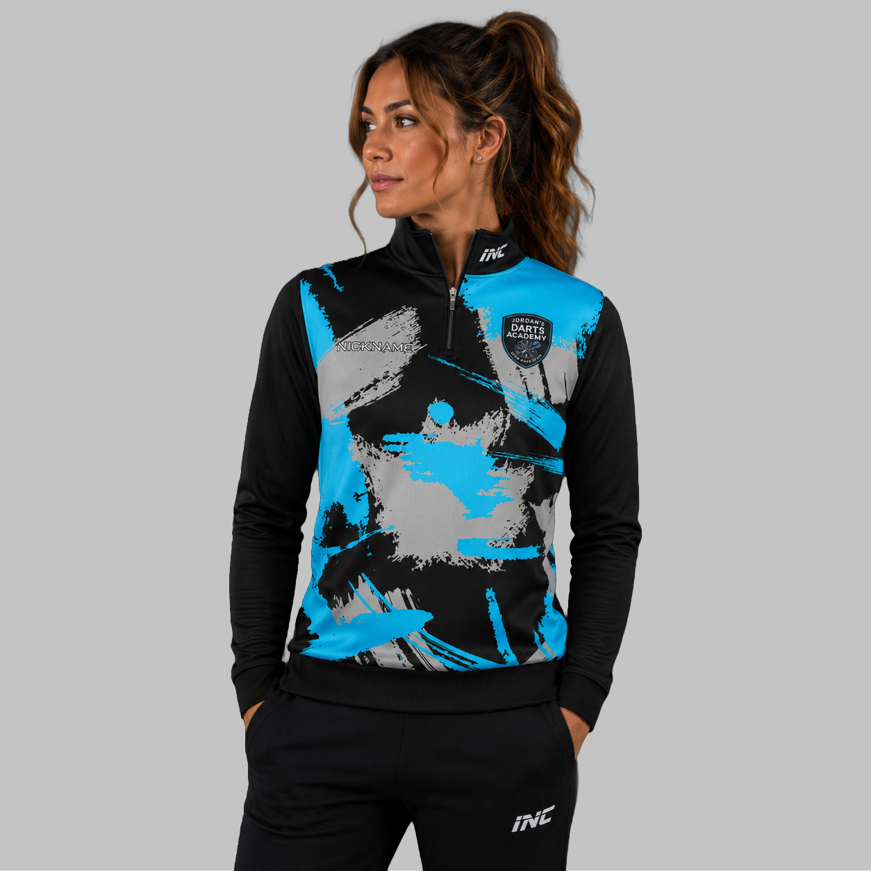 Front view of the unisex Jordan's Darts Academy Quarter Zip Midlayer, highlighting the athletic team styling, stand-up collar, and official academy crest.