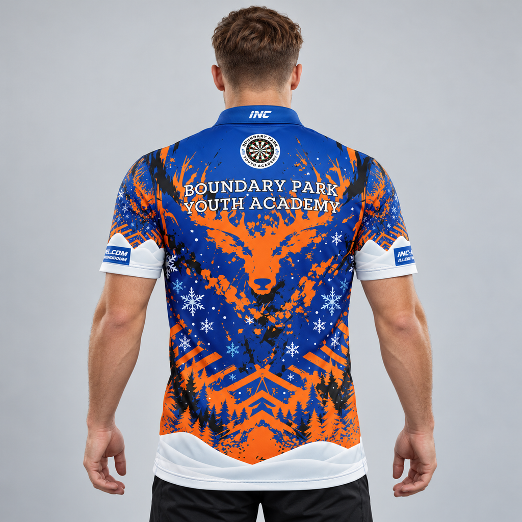 Back view of the TRADE Official Boundary Park Youth Darts Academy Christmas Shirt displaying prominent Boundary Park Youth Academy back text, circular crest on upper neck, INC collar logo, winter graphic pattern, and illegitiminoncarborundum text across the lower hem